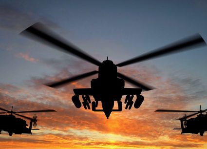 Silhouette of helicopter over sunset