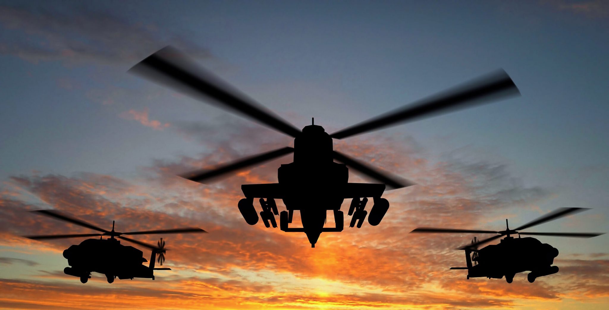 Silhouette of helicopter over sunset